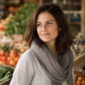 Femme au marché devant étal de légumes